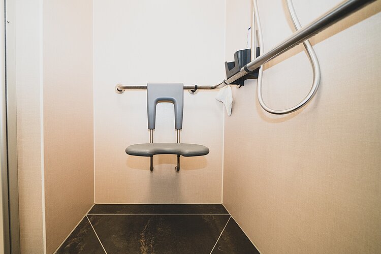 Barrierefreier Duschplatz mit ergonomischem Sitz, Haltegriffen und Duschkopf
